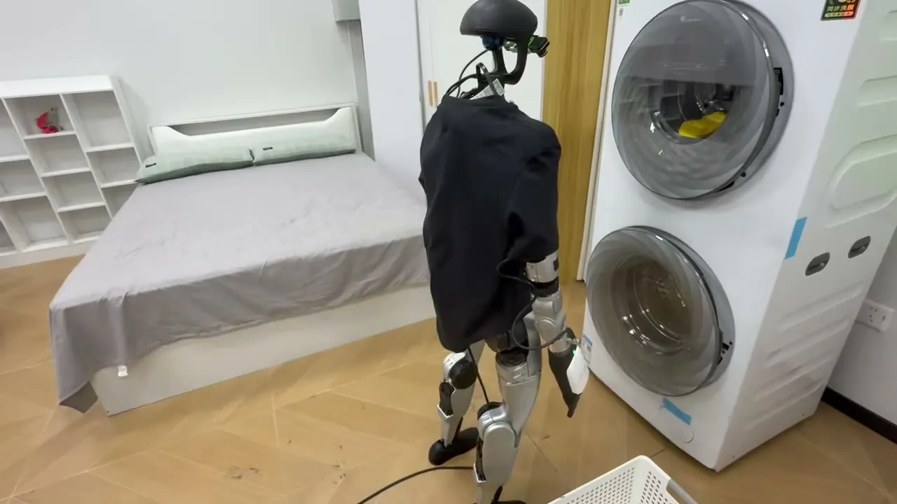 G1 standing in front of a washing machine during the pick_clothes_from_washing_machine task, exocentric view